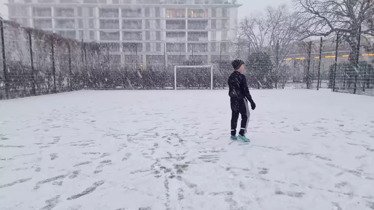 There are coaches who know nothing but cold. Their whole season is built across months when the wind bites and the grass crunches underfoot, and they have long since made their peace with it. Then there are coaches who only encounter the real cold occasionally, where most sessions pass in bearable conditions and the truly brutal mornings come as a kind of seasonal shock to the system. Either way, cold conditions demand a different mode of thinking. They are not simply an inconvenience to push through — they are a genuine challenge that, if handled poorly, can put players at risk, drain the energy from a session, and leave everyone counting down the minutes until they can get back inside. What follows is a collection of twenty practical, field-tested tips for coaches navigating training in the cold. Some of these are about logistics and planning. Others are about mindset, communication, and the small decisions that shape the feel of a session when everything around you is working against you. None of them are theoretical. All of them matter. Before You Even Arrive 1 Decide Whether It Is Actually Safe to Go Ahead This sounds obvious, but it deserves deliberate thought before every cold-weather session, not a cursory glance out the window. Can the session run safely? Is the temperature so extreme that it poses a genuine risk to players? Is the surface playable, or has frost turned the grass into something closer to concrete? Are the paths and entrance routes safe for players to walk on without slipping? These are not hypothetical questions — they are the foundation of your risk assessment, and the answers need to come before anything else. A session that goes ahead when it should not have is always harder to justify after the fact than one that was postponed out of caution. The simplest question to ask yourself is whether you would be comfortable explaining your decision to a parent if something went wrong. If the answer is uncertain, lean toward calling it off. 2 Think Through How Journeys Might Be Affected Cold weather does not just affect the pitch. It affects the roads, the buses, the trains, and the families trying to get their children to training in time. If conditions are icy or wintry, you can expect some players to arrive late, and others to not arrive at all — particularly those coming from more rural or remote areas where conditions are often worse and transport links are thinner. Plan your session with that variability in mind. Have an arrival activity ready that players can slot into as they turn up at different times, so those who arrive early are not standing around waiting while those who are still on the road feel like they have already missed something important. A flexible opening fifteen minutes costs you nothing and communicates to players and parents that you have thought this through. 3 Reconsider Your Session Length A regular session might run for ninety minutes or two hours. That duration is built around normal conditions — conditions that allow players to get warm, stay warm, and sustain their focus across a full evening of work. Cold weather changes the equation. The longer players are out there, the harder it becomes to keep them properly warm, and the more the discomfort starts to override the learning. Shortening the session is not a failure of planning — it is intelligent management of the circumstances. Players still get meaningful time on the ball and in the game, but you are not stretching the session past the point where the cold starts doing more harm than good. A sixty-minute session that crackles with energy and movement will always outperform a ninety-minute one where players are half-frozen and going through the motions by the end. The Surface and Equipment 4 Check the Surface Carefully Before You Set Up Even if you have decided the session is safe to proceed, the surface needs its own assessment once you arrive. Frost and freezing temperatures change the character of a pitch significantly. Grass that is normally forgiving becomes firmer and harder underfoot, which increases the physical impact of every contact — a slide tackle on frozen ground is a different proposition to the same challenge on a normal surface, and a simple fall can hurt a lot more. Astroturf and concrete surfaces can become slippery in a way that is not always visible until someone is already on the floor. Walk the full surface before players arrive. Note any patches that are particularly firm, slippery, or uneven, and cone them off where you can. Knowing the surface intimately also helps you configure your session layout thoughtfully — placing activities away from the worst areas, or adjusting the shape of your pitch so that the dodgiest corners are not in regular use. 5 Talk to Players About Their Footwear Footwear matters more in the cold than coaches often give it credit for, and it is an area where a quick conversation or a message to parents before the session can make a real difference. Players who normally wear studs on grass may need to reconsider on a harder, frostbitten surface — the extra firmness can make studded boots uncomfortable and potentially unsafe, and a switch to astros or a flatter shoe is often the better call. Players who arrive in regular sneakers on an icy surface are another issue entirely, and having that conversation in advance means fewer surprises on the night. You do not need to be prescriptive about this, and parents generally know their children's kit better than anyone — but a short, friendly heads-up about the surface conditions and what that might mean for footwear shows that you are paying attention to the details, and it keeps the decision in their hands with the right information to act on it. 6 Encourage Players to Dress for the Cold, Not Just for Playing There is a particular kind of optimism that leads young players to show up in shorts and a thin top when the temperature has been hovering near zero all day. Part of coaching in cold conditions is managing that optimism gently but firmly. Remind players and parents ahead of time: more layers are better, tracksuit bottoms over shorts where possible, and hats and gloves are not just acceptable but encouraged. The logic of it all is straightforward — it is far easier to take a layer off once you are warmed up than it is to suffer through an entire session having not worn enough. Consider keeping a few spare items in your kit bag for the players who inevitably turn up underprepared. Gloves, in particular, are worth having on hand — they are small, easy to carry, and hands get cold faster than most players expect, especially during stoppages and breaks. Having a spare pair to offer a player who is struggling can turn a miserable session into a manageable one, and it costs very little to be that prepared. It is far easier to take a layer off once you are warmed up than it is to suffer through an entire session having not worn enough. 7 Explore Whether an Indoor Space Is Available Not every venue has this option, but if yours does, think about how you might use it. An indoor area does not have to replace the outdoor session entirely — it can serve as a complement to it in ways that are genuinely useful. You might use it for your warm-up, getting blood moving before heading outside, or for a tactical or conceptual conversation you would normally have pitched-side, where players can listen and engage without the cold chewing away at their attention. Some of the most effective cold-weather sessions are structured around a split — a period inside doing something cognitive or technical in a contained space, and then a period outside applying that thinking in a live practice or game. Players arrive having already had a chance to think through what they are working on, so the outside time is focused and purposeful, and the movement keeps them warm from the moment they step out. Looking After Your Players 8 Keep Medical Conditions in the Front of Your Mind Cold air is a known trigger for respiratory conditions, and asthma in particular is common enough among young players that most coaches will have at least one or two players dealing with it at any given time. Cold temperatures cause the airways to constrict, which makes breathing harder, and that effect is compounded by the physical demands of training. Before a cold session, it is worth checking in with any players who have relevant medical conditions and asking them directly how they expect to be affected and what they might need. This is not about building anxiety or making a production of it — it is simply about having the right information so that you are not caught off guard if a player needs to step back or slow down. Make sure those players have their inhalers or any other relevant medication accessible, and brief another adult, if one is present, on what to watch for and what to do. 9 Think About How You Would Handle Injuries Cold weather changes the nature of physical contact in a way that is easy to underestimate until it happens. A ball travelling at pace into someone's thigh or face stings considerably more when the temperature is low, and players who would normally shake something off and continue may find themselves needing a moment to recover. A harder surface means falls land differently, and the kind of minor knock that barely registers in August can be genuinely painful in January. Beyond the minor stuff, think through how you would manage a more significant injury — one that requires the session to stop or that needs real medical attention. Do you have a blanket with you to keep a player warm while you wait for help or while a parent is called? Is your first aid kit stocked and accessible? These things should be in order for every session, but in the cold the stakes are slightly higher and the margin for delay is slightly thinner. Running the Session 10 Get Players Moving the Moment They Arrive Standing around in the cold while waiting for the rest of the group to show up is one of the quickest ways to sap the energy from a session before it has even started. Have an arrival activity already set up before the first player walks through the gate — something simple and self-explanatory, where a player can join in as soon as they get there without needing to be briefed or organised. A small rondo, a possession game, a technical warm-up exercise with a whiteboard explanation of the rules: the specifics matter less than the principle, which is that movement should begin immediately. As players arrive, direct them straight to the activity rather than gathering them in a group first. This keeps things informal and flowing, reduces the time anyone spends standing still, and creates a sense of energy from the very start of the session that is much harder to generate if you let the cold settle in during the opening minutes. 11 Warm Up Properly — and Take It Seriously In normal conditions, a structured warm-up is good practice. In the cold, it is non-negotiable. The risk of muscular injury rises significantly when players go from cold and static to high-intensity activity without adequate preparation, and tight, unprepared muscles in freezing weather are far more vulnerable to strains and tears than they would be on a mild evening. A dynamic warm-up — one that incorporates movement, mobility, and a progressive increase in intensity rather than simply holding static stretches — does the job properly. The goal is to raise the heart rate, increase blood flow to the working muscles, and get the joints moving through their full range before anyone starts working at pace. Ten minutes done well here will save you from dealing with an injury later in the session. 12 Keep Breaks Short and Intentional Breaks are still necessary in cold-weather training — players need to recover and hydrate just as they do in any other session — but the nature of cold weather means that a break that runs too long stops being restorative and starts being counterproductive. Players cool down quickly when they stop moving, and once the cold has set back in it takes time and effort to get the warmth back. The longer the break, the more of your session you will spend trying to re-warm players rather than actually working. Be deliberate and firm about break duration. Players will naturally drift toward extending them, especially if they are comfortable chatting or have started to feel the cold less acutely now that they are not running. That is fine — keep the communication light — but have a clear plan for when the break ends and transition back to activity with confidence and purpose. 13 Make Sure Players Are Drinking, Even in the Cold This is a detail that catches coaches and players out more often than it should. When it is cold, the instinct to drink fades — the body does not signal thirst in the same way it does in heat, and sipping cold water when you are already cold feels deeply unappealing. But physical exertion generates fluid loss regardless of the temperature, and players who are not drinking are not performing or recovering at their best. Build drink breaks into the session structure and prompt players to take them even when they say they do not need to. If your venue allows it, warm water or a hot drink can make this considerably more appealing. The habit of hydrating in cold conditions is one that young players in particular need to be actively encouraged to develop, and the session is an ideal moment to reinforce it. 14 Maximise Ball Rolling Time and Minimise Stoppages There is rarely a compelling reason for line drills at any time of year in modern coaching. In the cold, there is genuinely no reason for them at all — a line of players waiting for their turn is a line of players getting cold, getting bored, and disengaging from the work. The whole structure of cold-weather training should tilt heavily toward activities that keep everyone moving as much of the time as possible. Small-sided games, possession exercises, and formats where players are constantly involved are your friends here. When you do need to stop the session to make a coaching point, keep it concise and purposeful — say what needs to be said, demonstrate if necessary, and get back to the activity quickly. Extended technical discussions pitched-side in sub-zero temperatures do not land well with anyone, and the quality of listening drops sharply the longer players are standing still. A line of players waiting for their turn is a line of players getting cold, getting bored, and disengaging from the work. 15 Keep the Mood Light and the Energy Up When players are cold and uncomfortable, they are already fighting against the conditions in a way that drains their emotional reserves. The last thing they need on top of that is a coach who is heavy, serious, or given to long monologues about what the team is getting wrong. Cold weather sessions ask something extra of players just by virtue of existing, and the best coaches acknowledge that implicitly through the energy they bring. Keeping things fun is not about lowering the standard or abandoning the work — it is about creating an atmosphere where players feel positive enough to engage with the challenge in front of them. A joke, a bit of competitive energy in a small-sided game, a word of genuine praise: these things cost nothing and they matter more in the cold than in any other context, because they are working against the emotional drag that the conditions naturally create. 16 Check In with Your Players and Actually Listen Ask players how they are doing during the session. Are they warming up? Are they comfortable? Are they struggling with the cold in a way that is affecting how they feel? These questions take seconds to ask and they signal to players that their experience of the session matters to you, not just what they are producing on the ball. The other side of this — and it matters — is that you actually listen to the answers. Players are notorious for moaning about minor discomforts, and coaches who have been at this for a while can develop a kind of selective deafness to complaints that allows genuinely important signals to get lost. Cold-weather sessions require a more active kind of listening: taking seriously when a player says they are not warming up, or that they are feeling the cold differently than usual, rather than assuming it is just noise. Sometimes it is just noise. But sometimes it is not, and knowing the difference is part of the job. Specific Situations 17 Give Your Goalkeepers Special Attention The physiology of goalkeeping and the demands of the cold are a difficult combination. An outfield player in a small-sided game is almost constantly moving, and the physical activity of running, turning, and competing keeps the warmth in. A goalkeeper in a large goal, watching a practice unfold at the other end of the pitch, is not getting nearly enough of that. The cold sets in faster and deeper for keepers than for anyone else in a typical training session, and a goalkeeper who has been standing in goal for an extended period is not only uncomfortable — they are also at greater risk of injury when called upon to dive or react explosively on a hard surface. The solution is straightforward: integrate your goalkeepers into outfield activities wherever you can, which is good coaching practice year-round and particularly important in the cold. When they are in goal, encourage them to keep moving — small feet, staying active, not simply waiting for the action to come to them. And if the ground is especially hard, be sensible about how much full diving you are asking of them; the impact of hitting a frozen surface repeatedly is not trivial, and there is no need to expose keepers to unnecessary injury risk just to replicate a game environment. 18 Be Ready to Make Tough Calls as the Session Goes On Conditions change during a session. A surface that was firm but manageable at the start of the evening can become significantly harder as the temperature continues to drop. A night that was cold but bearable at kickoff can turn properly hostile by the time you are an hour in. The assessment you made before the session does not automatically hold for the full duration of it, and part of your job is to keep evaluating as things evolve. If the conditions deteriorate to a point where you feel the risk has changed materially, do not hesitate to call the session early. Players will often protest — there is something compelling about being out there in the cold together that makes people reluctant to stop — but their enthusiasm is not the determining factor here. Yours is. Brief parents in advance that an early finish is a possibility in cold conditions and encourage them to stay close or be reachable, while also having a plan for any players who cannot be collected immediately. 19 Manage Your Matchday Substitutes Thoughtfully Most of the principles above apply directly to matchdays as well as training sessions, but matchdays bring an additional challenge that training does not: substitutes. A player on the bench in a cold-weather game is in a similar position to that goalkeeper standing in a large goal — they are not generating the heat that comes from playing, and the cold finds them quickly. Managing that is part of matchday planning. Think carefully about how many players you take to a cold-weather game. Large squads mean large numbers sitting around, and that is difficult to manage well. When players are on the bench, keep them active — encourage them to move, jog the touchline, stay engaged with the game physically as well as mentally. Have a clear plan for rotating players to manage game time and keep them warmer, and make sure those coming off the pitch have something to put on immediately rather than standing in sweaty kit as the cold arrives. 20 Look After Yourself This one comes last, but it is not an afterthought. A coach who is cold is a coach whose attention is divided, whose patience is shorter, and whose ability to read the session and respond to what is happening in front of them is genuinely compromised. Your comfort is not a luxury — it is a precondition for doing the job well. Layer up properly: a good base layer, a mid-layer, a proper coat, a hat, gloves, and a snood at a minimum. Some coaches carry heat packs in their pockets, which is entirely sensible, and bringing a flask of something warm to sip on during the session is not indulgent — it is practical. When the session ends, do not linger in the cold. Get into your car, get the heating on, and have warm clothes ready for when you get home. The players go home to warmth; you should too.